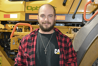 Picture of Danial Backsen, standing near a piece of heavy equipment.
